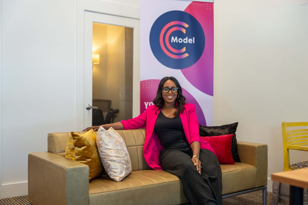 Photo of CModel Co-Founder Teasha Cable sitting on the couch in front of her office